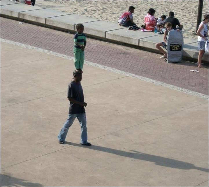Мальчик стоит на голове отца 